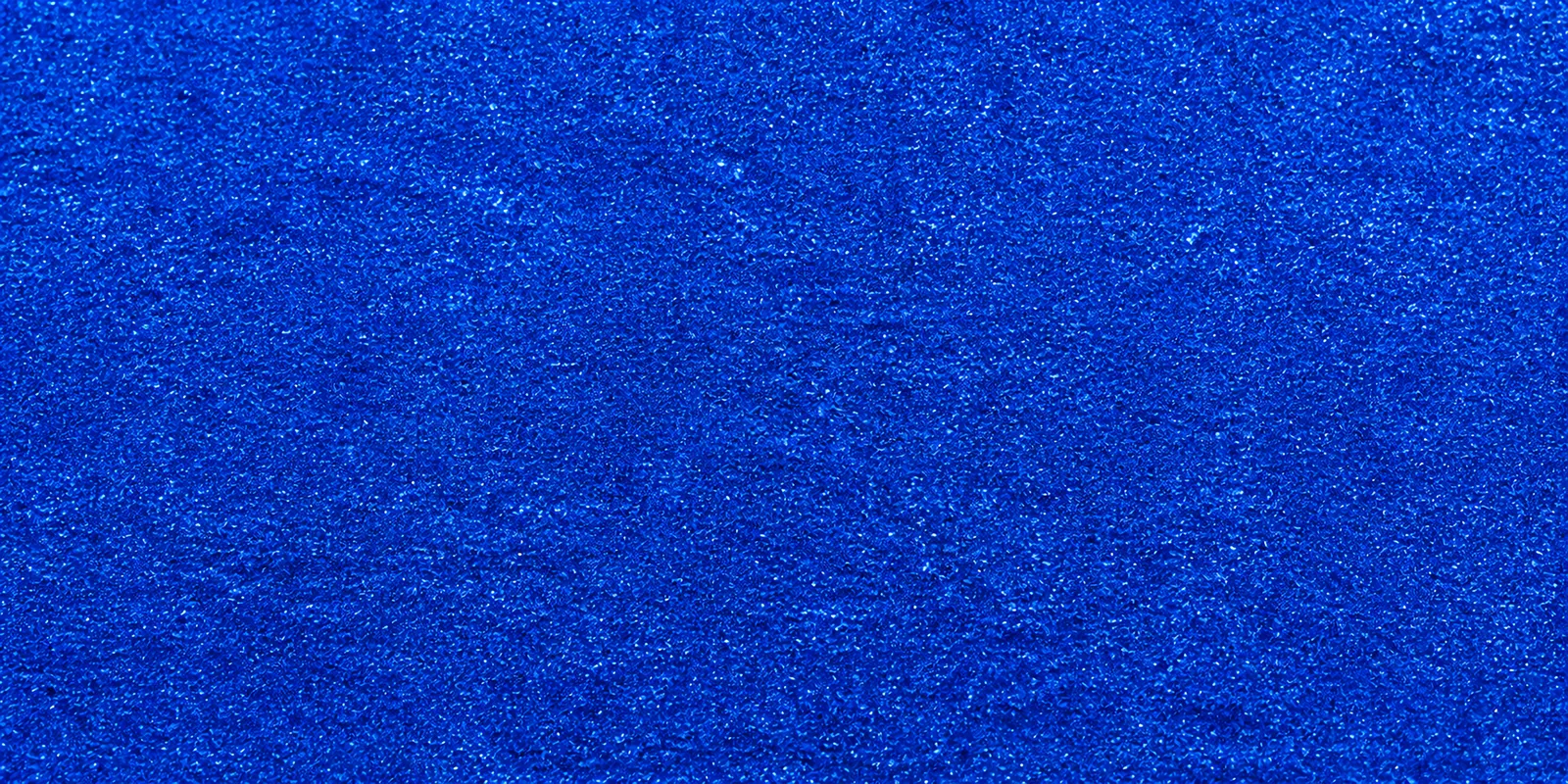 Macro del papel con glitter azul castillo luminoso, con las partículas separadas brillando sobre la hoja