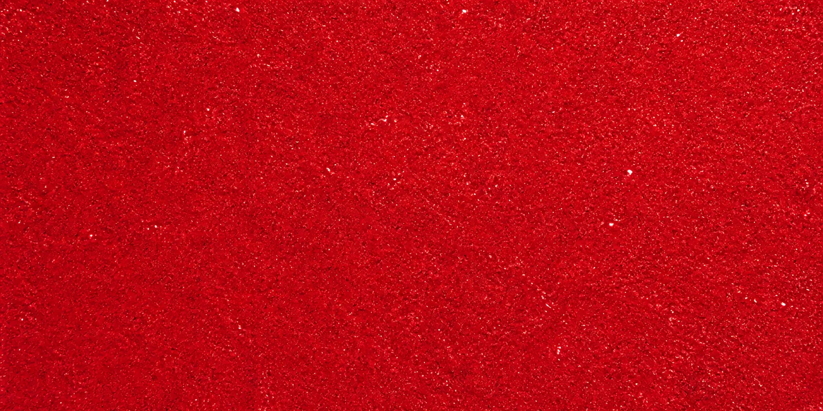 Macro del papel con glitter rojo corazon, con las partículas separadas brillando sobre la hoja
