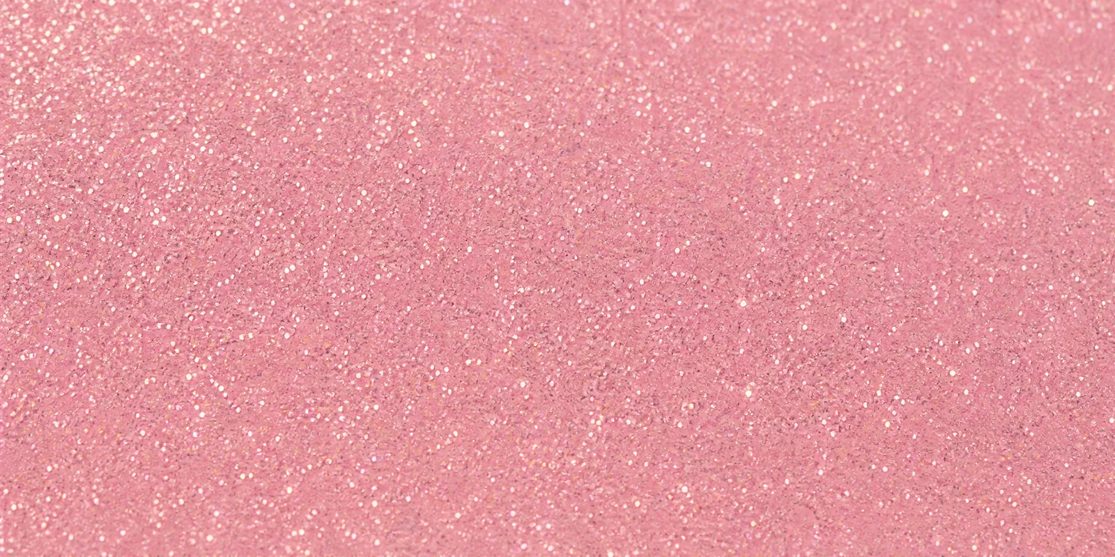 Macro del papel con glitter rosa melocotón, con las partículas separadas brillando sobre la hoja