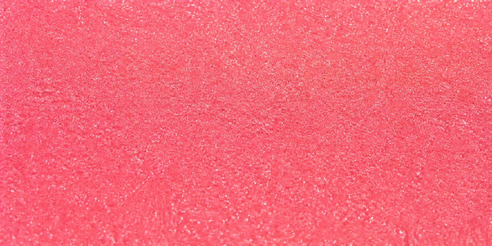 Macro del papel con glitter rosa neon magico, con las partículas separadas brillando sobre la hoja