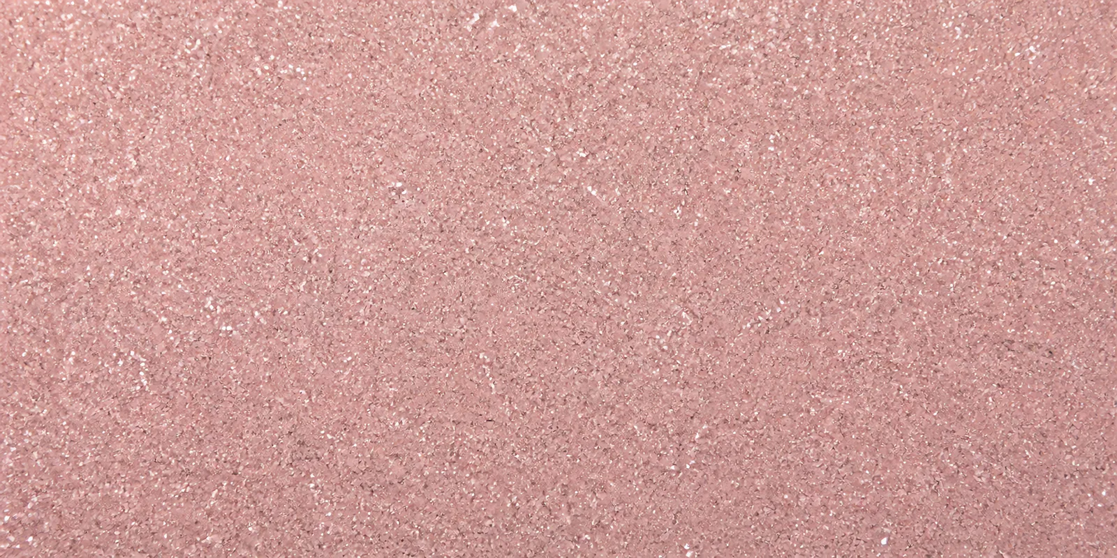 Macro del papel con glitter rosa romance, con las partículas separadas brillando sobre la hoja