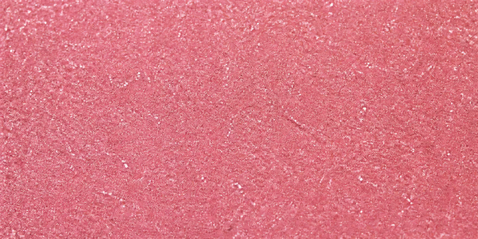 Macro del papel con glitter rosa tiara, con las partículas separadas brillando sobre la hoja