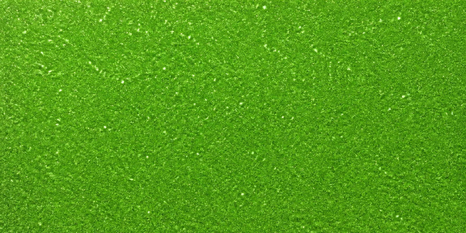 Macro del papel con glitter verde manzana encantada, con las partículas separadas brillando sobre la hoja