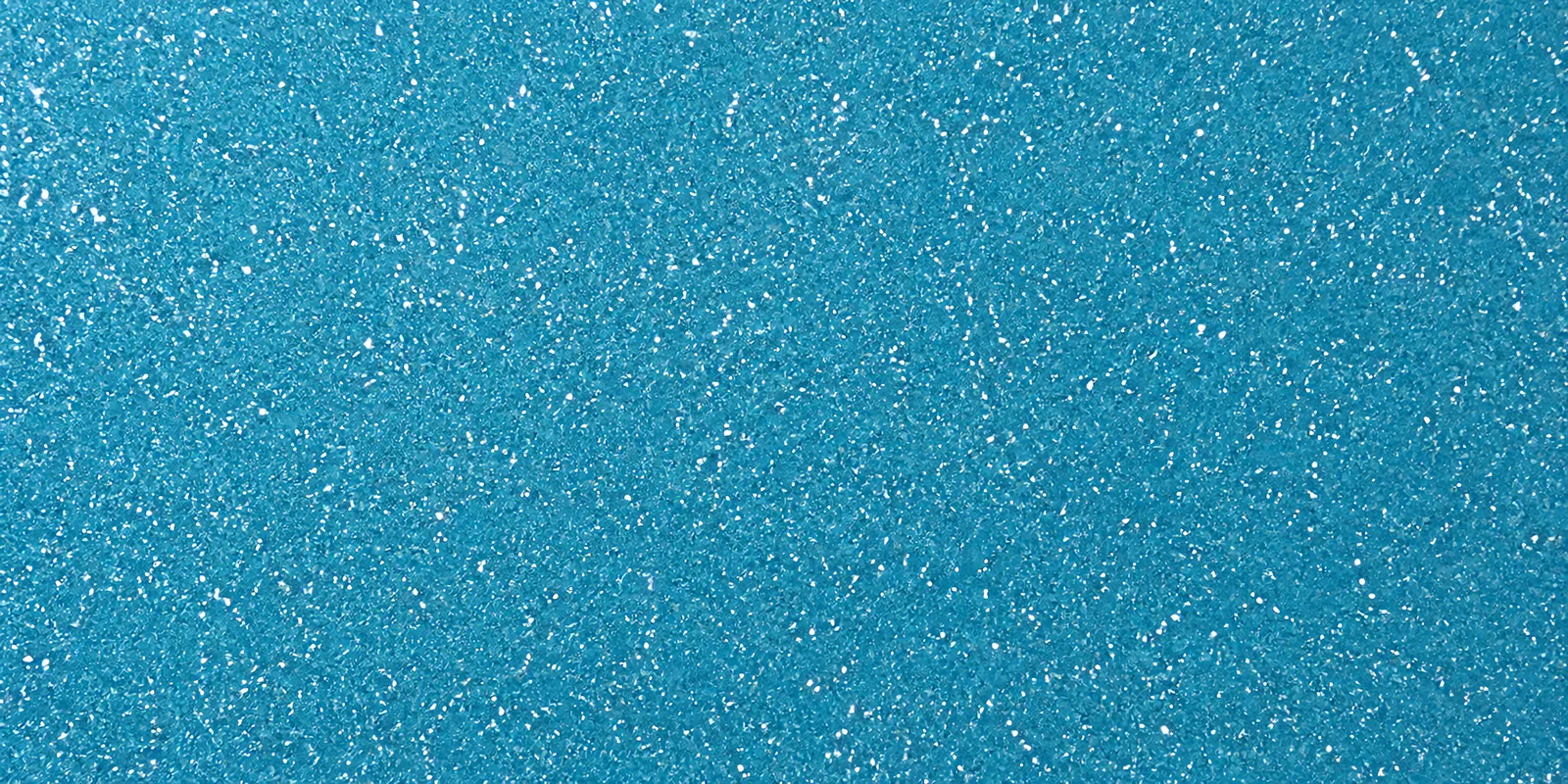Macro de una hoja celeste agua de Gliterina, con el glitter bajo el film plástico
