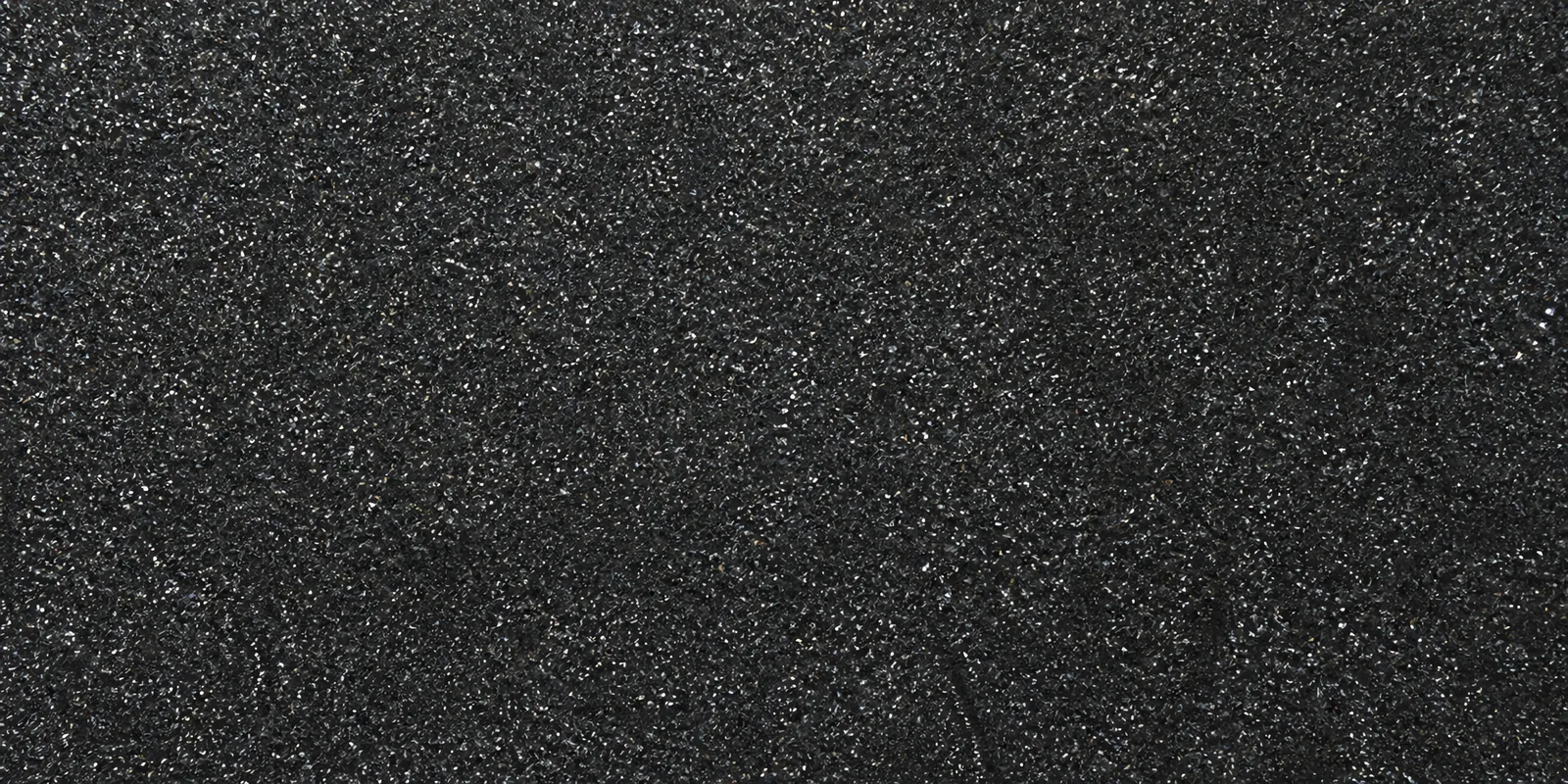 Macro de una hoja negro brillante de Gliterina, con el glitter bajo el film plástico