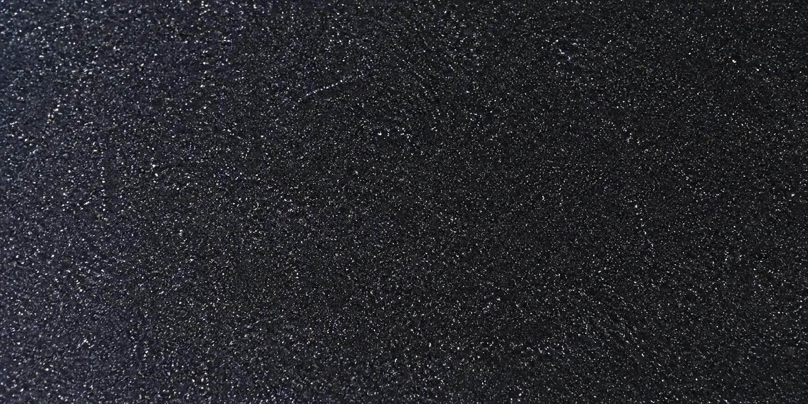 Macro de una hoja negro noche de Gliterina, con el glitter bajo el film plástico