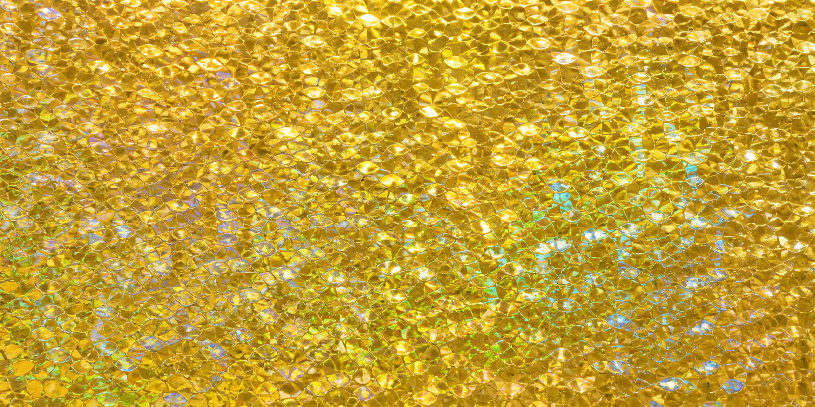 Superficie del papel metalizado Metalina, con el reflejo corriendo sobre la hoja, en el acabado dorado chita