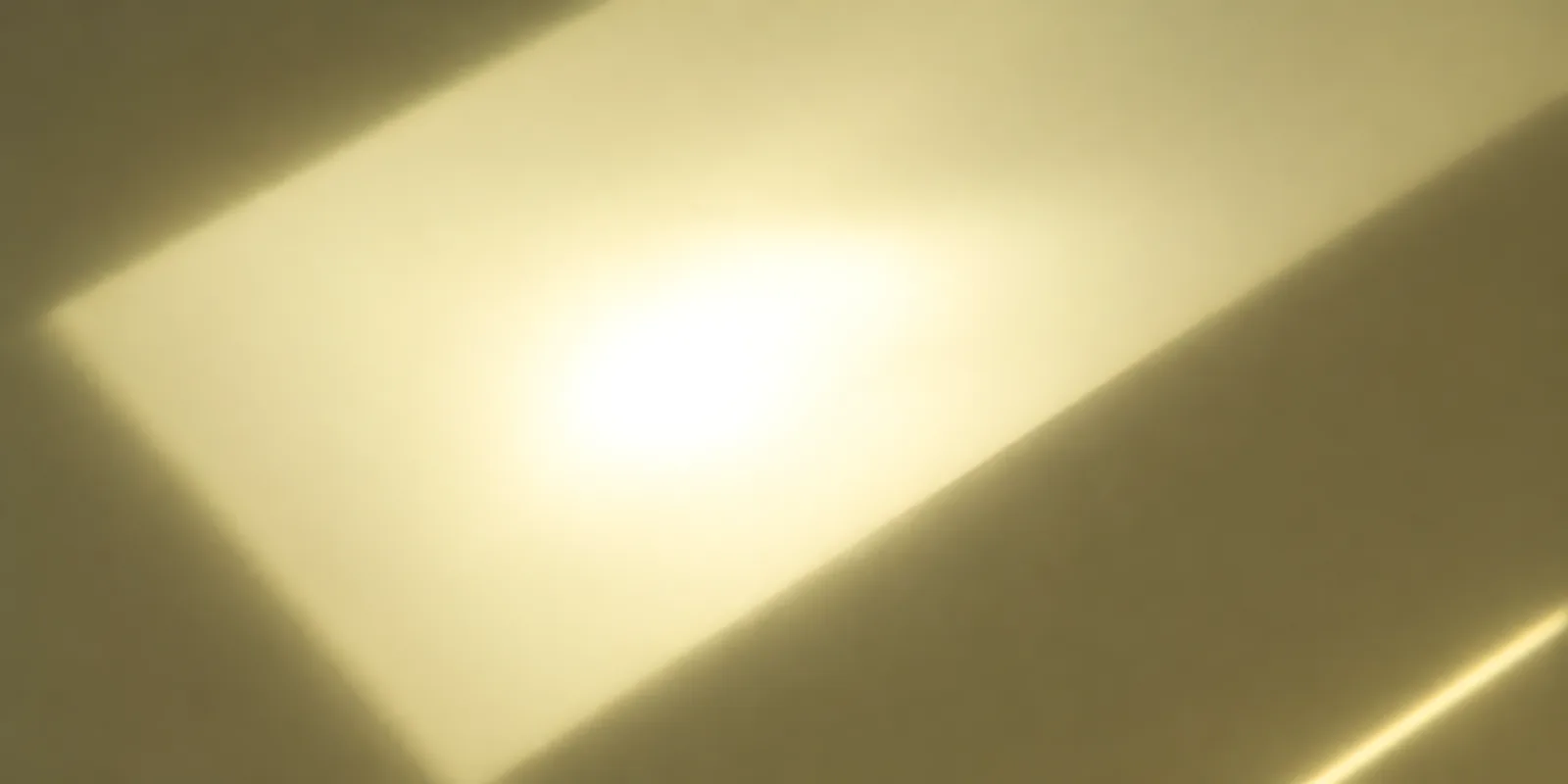 Superficie del papel metalizado Metalina, con el reflejo corriendo sobre la hoja, en el acabado dorado claro