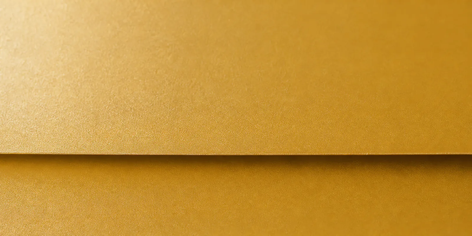 Detalle del papel perlado oro oscuro, con el satinado corriendo sobre la hoja