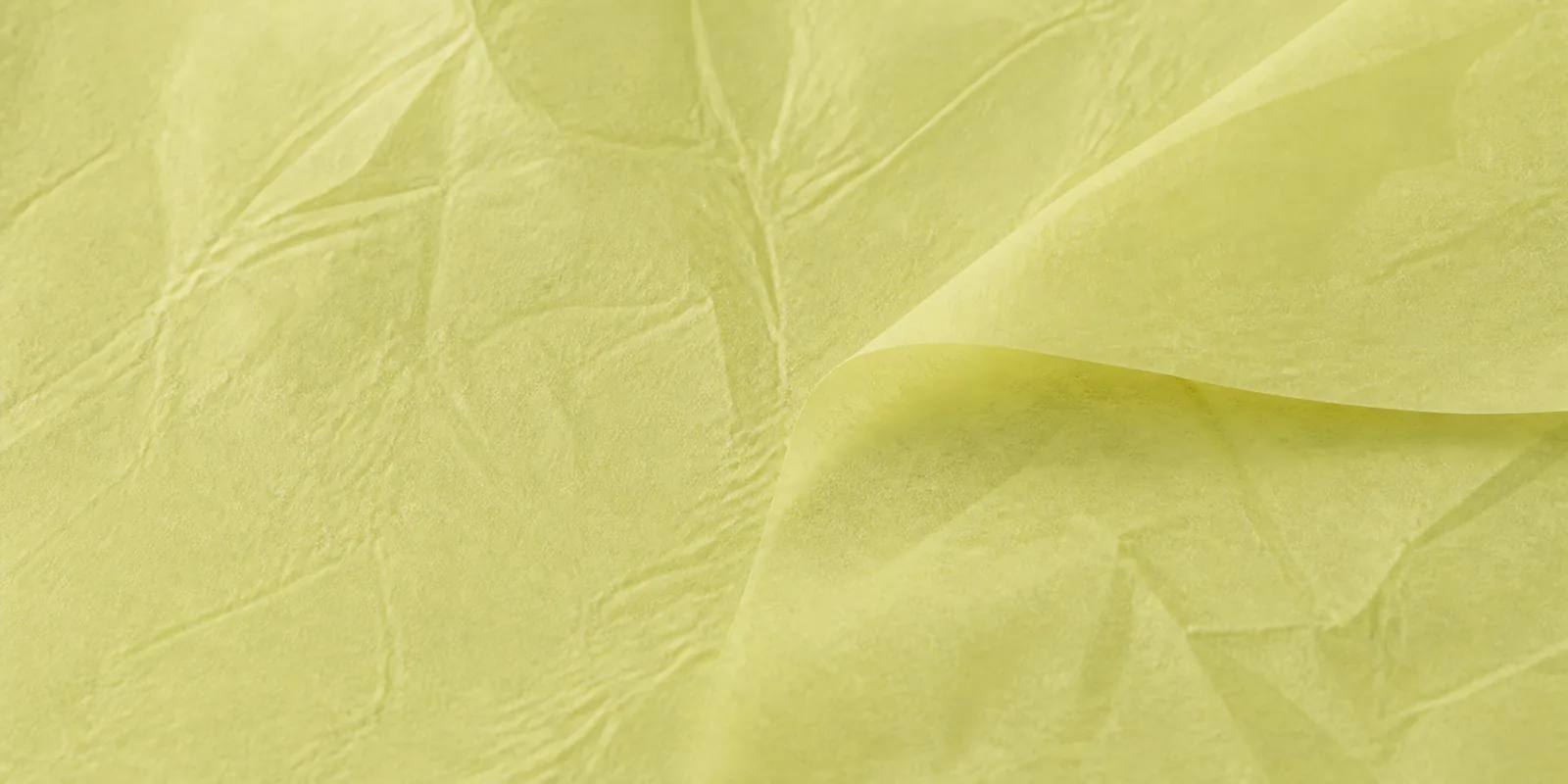 Textura del papel seda amarillo pastel, con sus arrugas finas y sus pliegues