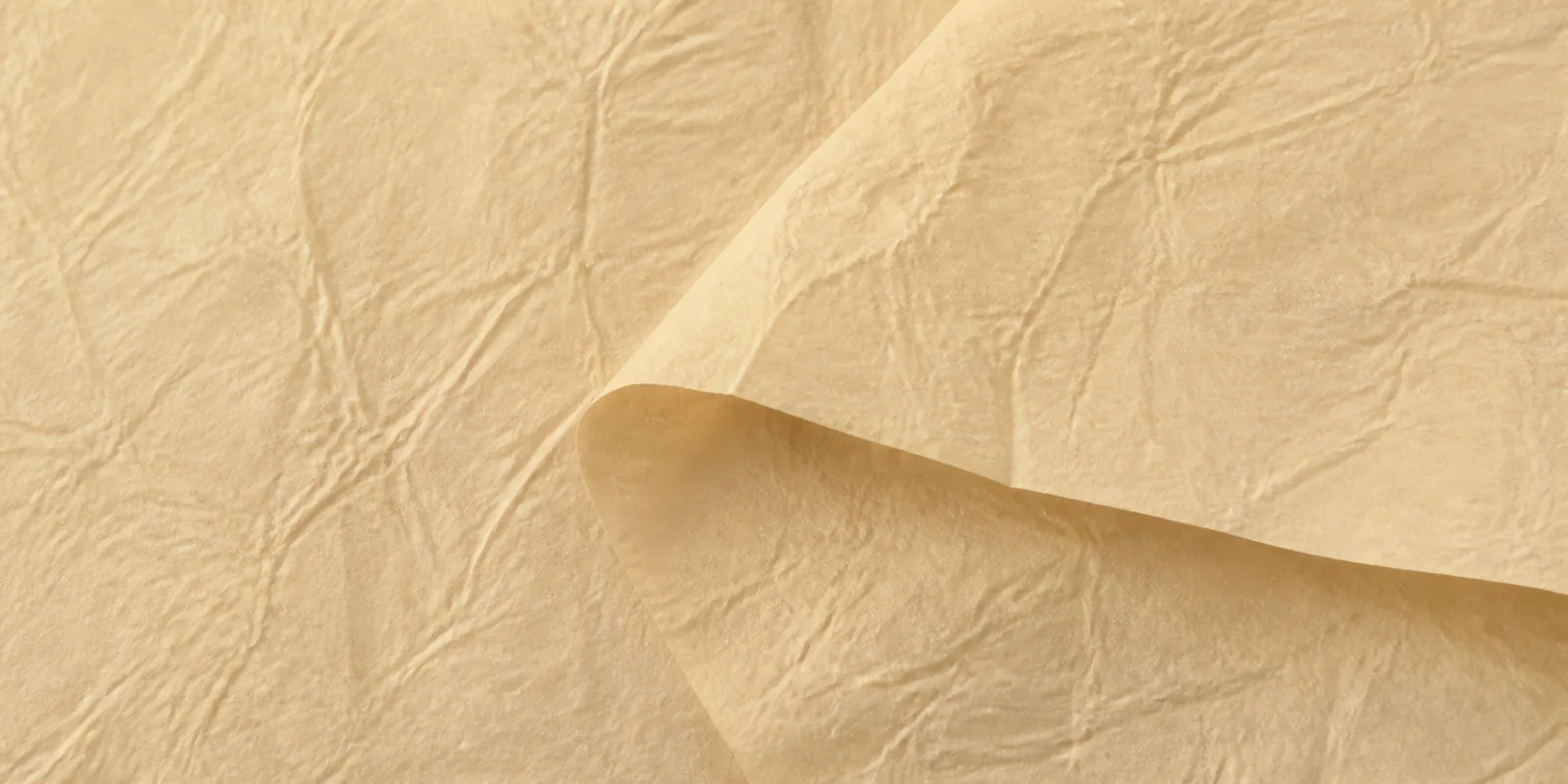 Textura del papel seda amarillo perlado, con sus arrugas finas y sus pliegues