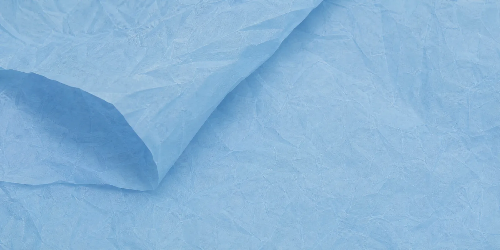 Textura del papel seda celeste cielo, con sus arrugas finas y sus pliegues