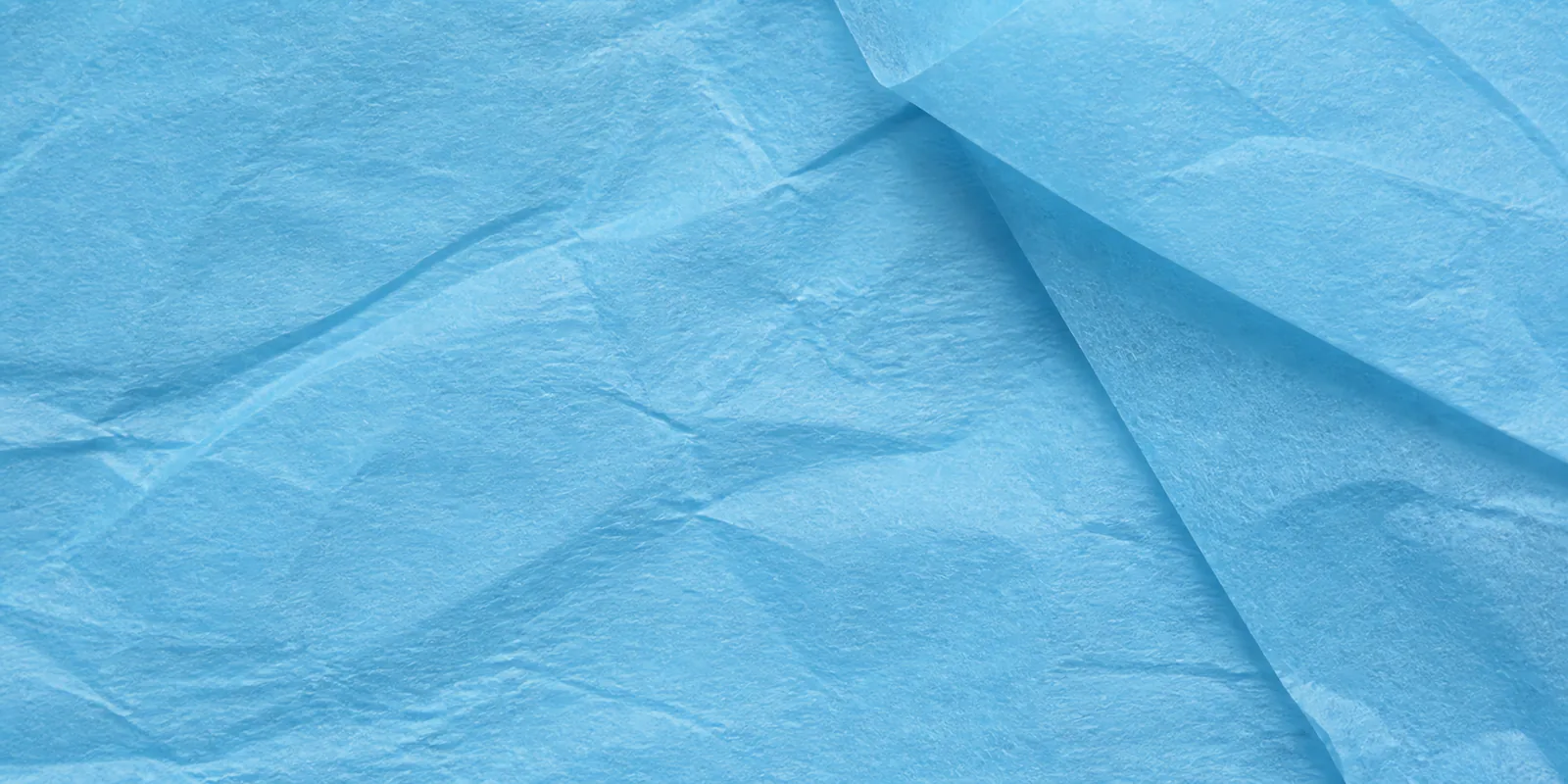 Textura del papel seda celeste pastel, con sus arrugas finas y sus pliegues