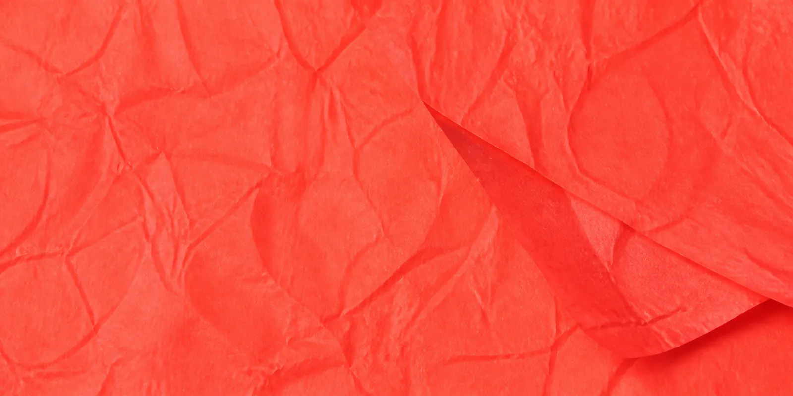 Textura del papel seda coral fluor, con sus arrugas finas y sus pliegues