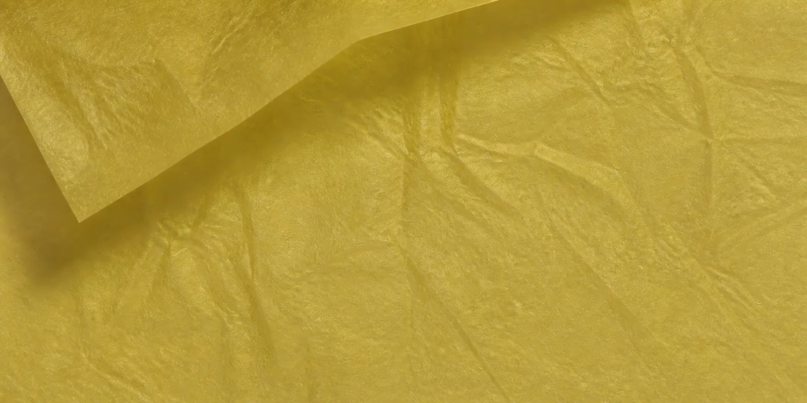 Textura del papel seda dorado, con sus arrugas finas y sus pliegues