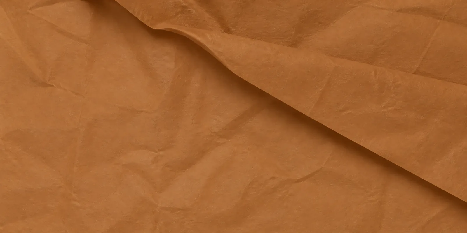 Textura del papel seda marrón clarito, con sus arrugas finas y sus pliegues