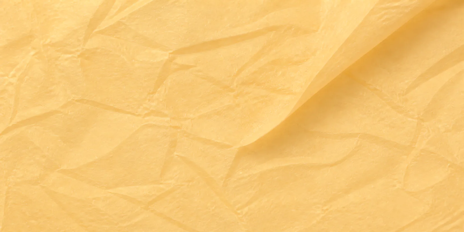 Textura del papel seda naranja pálido, con sus arrugas finas y sus pliegues