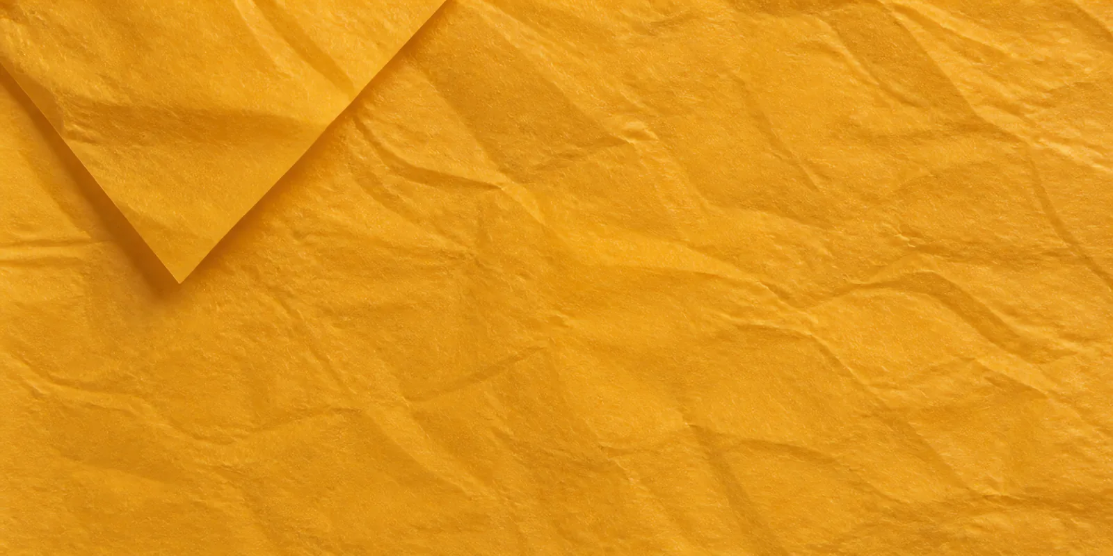 Textura del papel seda naranja pastel, con sus arrugas finas y sus pliegues