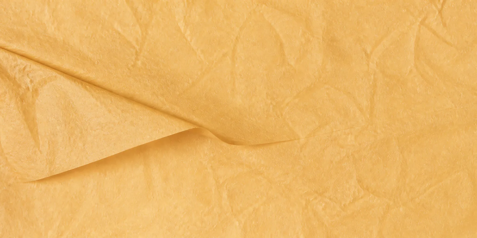 Textura del papel seda naranja perlado, con sus arrugas finas y sus pliegues