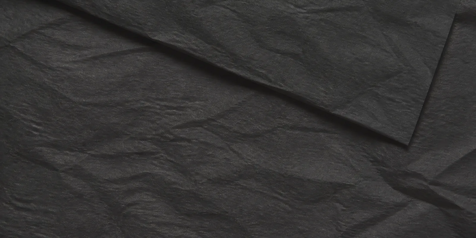 Textura del papel seda negro, con sus arrugas finas y sus pliegues