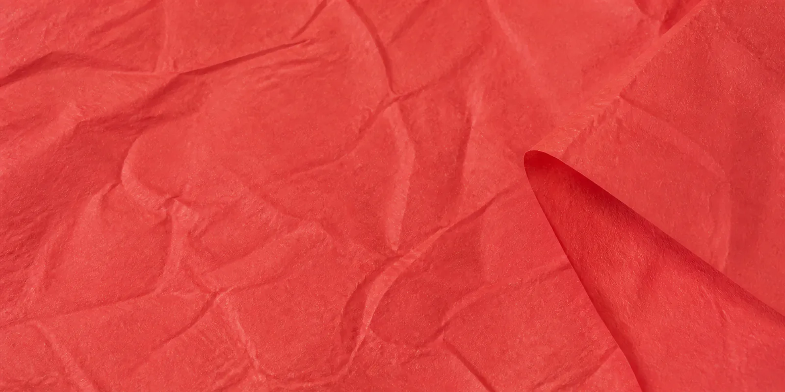 Textura del papel seda rojo carmesi, con sus arrugas finas y sus pliegues