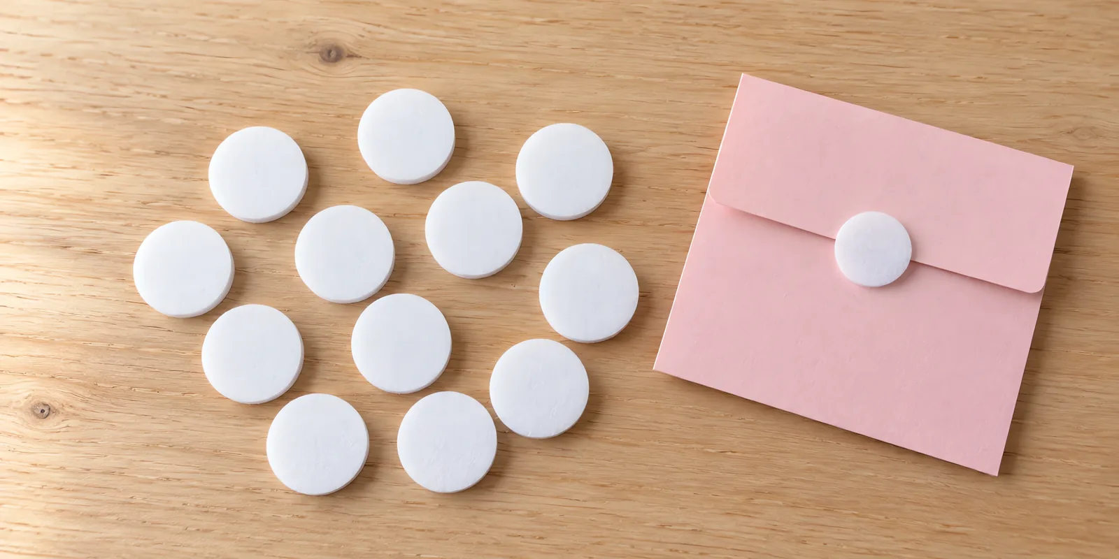 Doce círculos de abrojo blancos sobre la mesa, con una tarjeta cerrada con uno de ellos