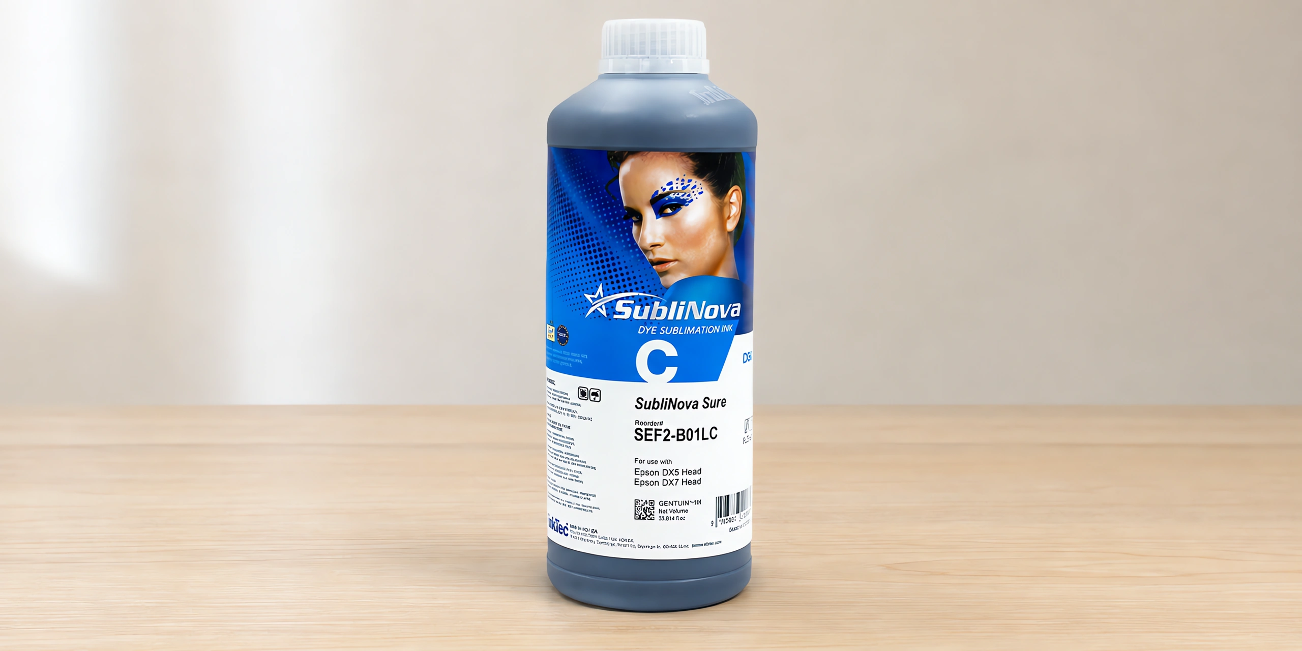 Tinta para sublimar de gran formato en su envase cyan con chip, sobre la mesa de trabajo