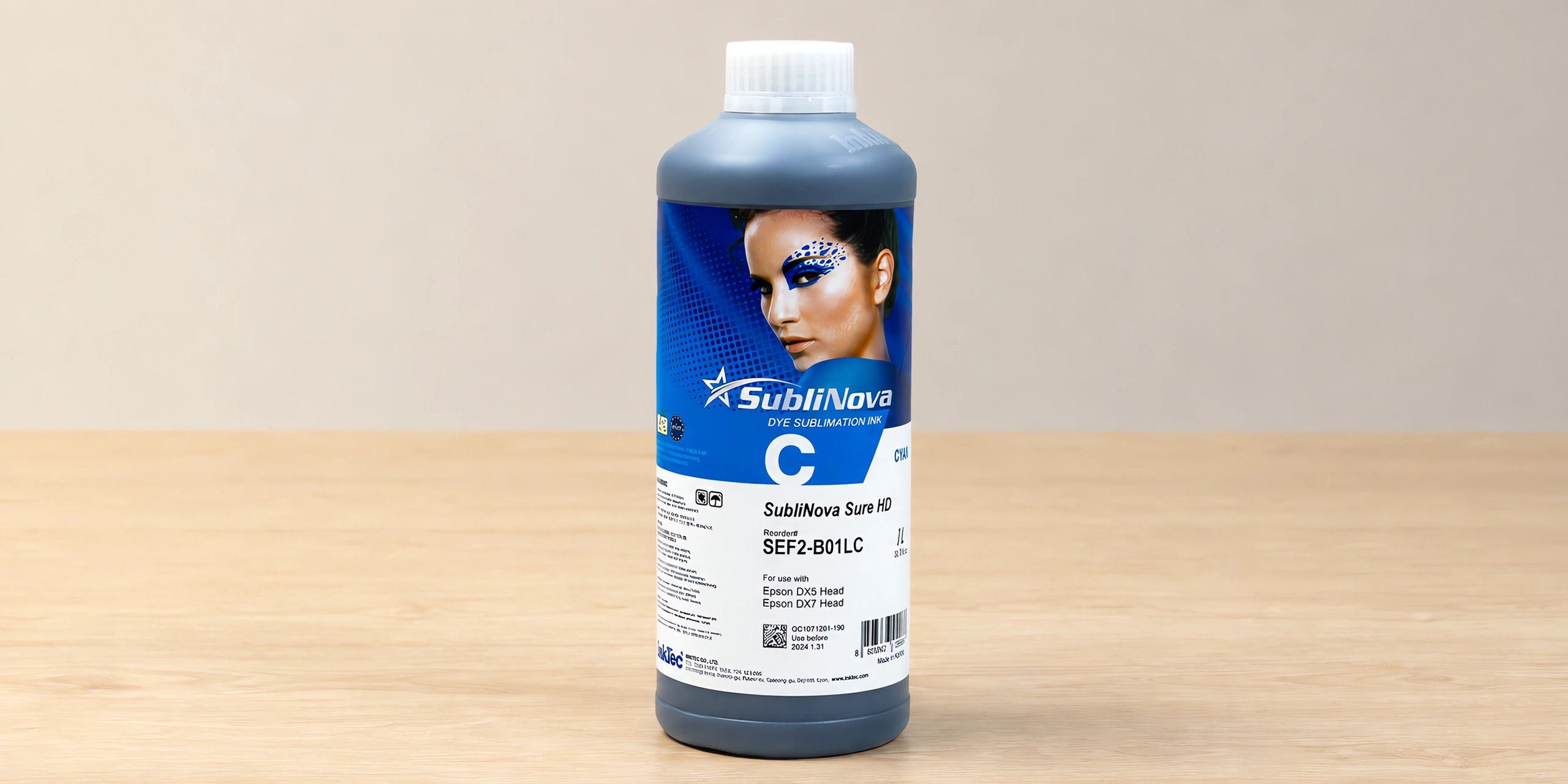Tinta para sublimar de gran formato en su envase cyan, sobre la mesa de trabajo