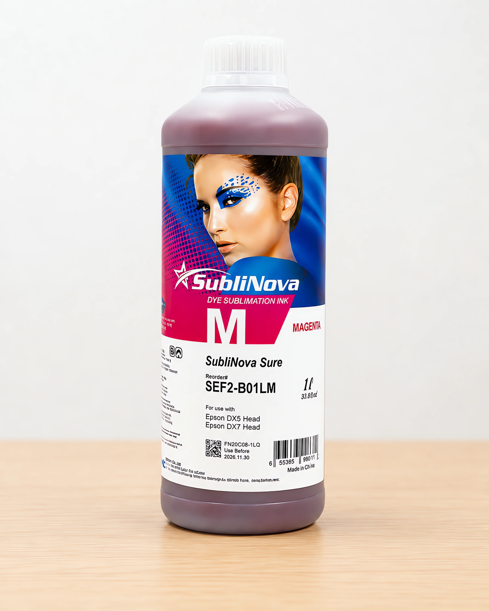 Tinta para sublimar de gran formato en su envase magenta, sobre la mesa de trabajo
