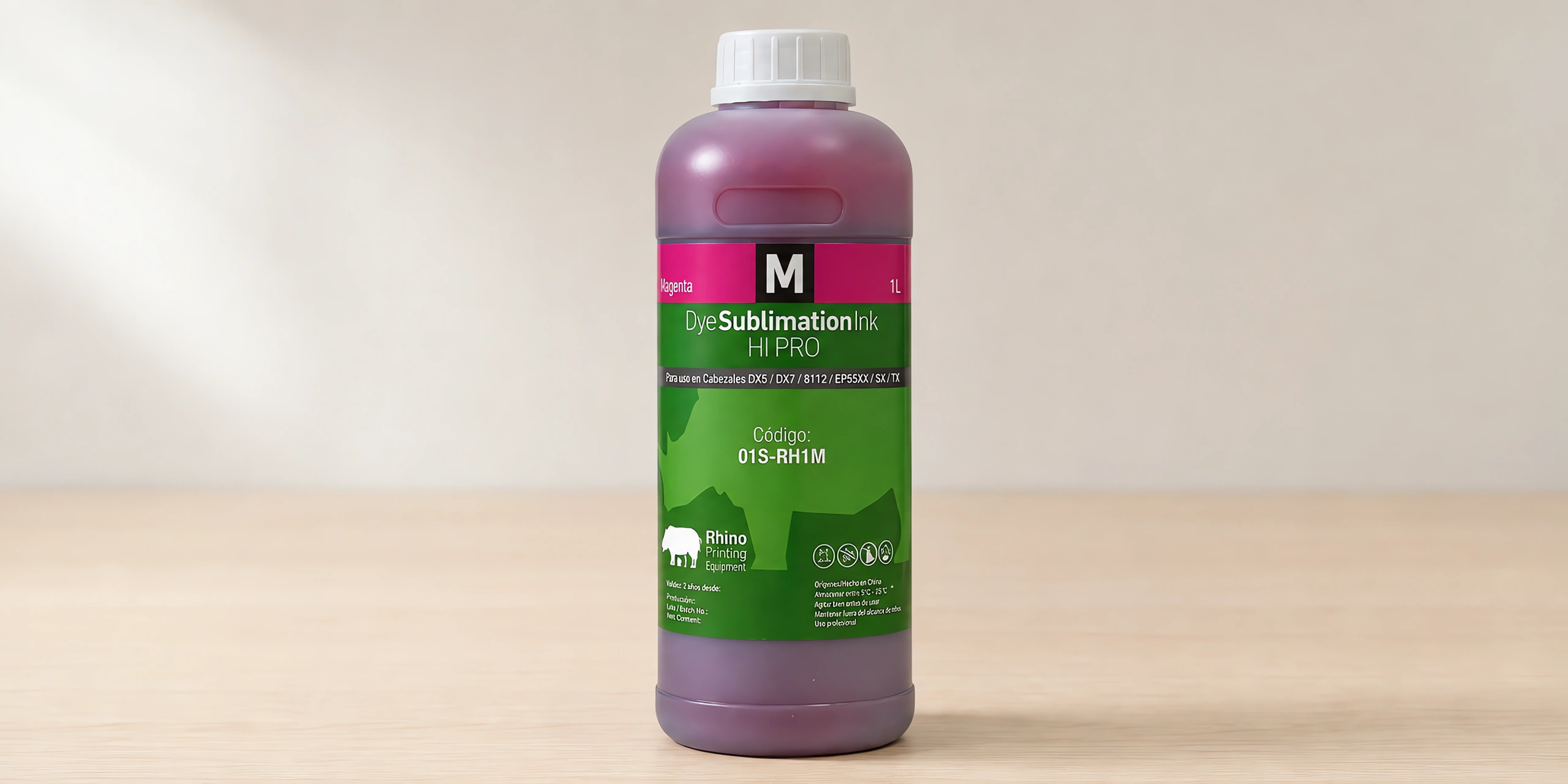Tinta para sublimar de gran formato, línea Rhino en su envase magenta, sobre la mesa de trabajo