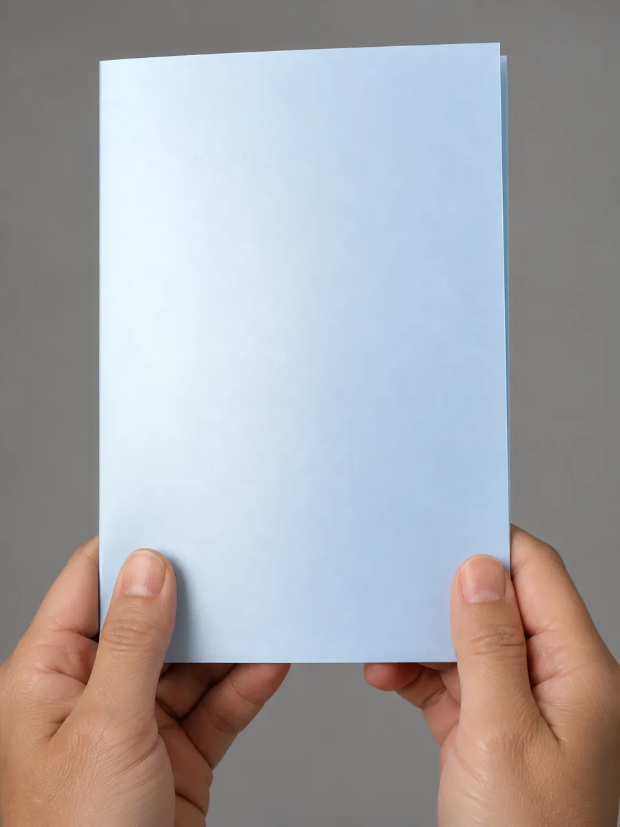 Manos sosteniendo una tarjeta doblada en papel perlado gris