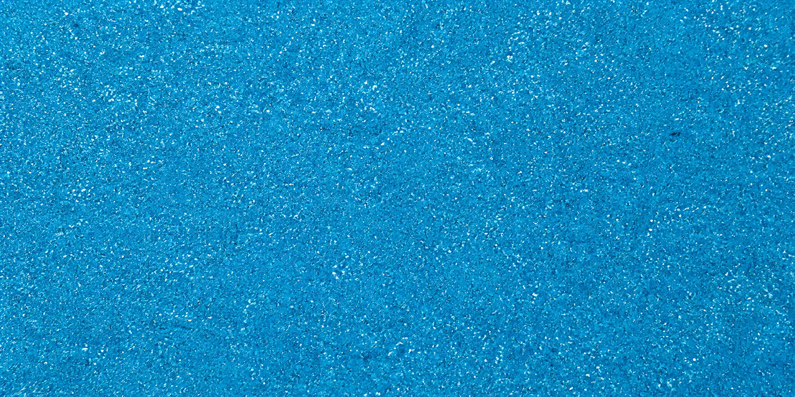 Macro del papel con glitter azul gema del dragon, con las partículas separadas brillando sobre la hoja