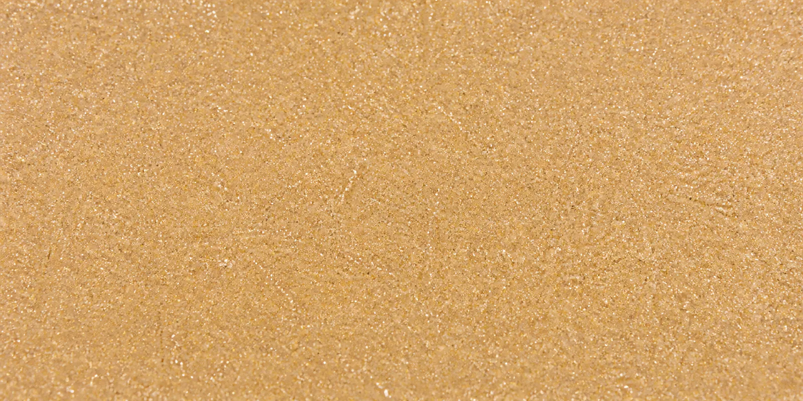 Macro del papel con glitter coral del mar, con las partículas separadas brillando sobre la hoja