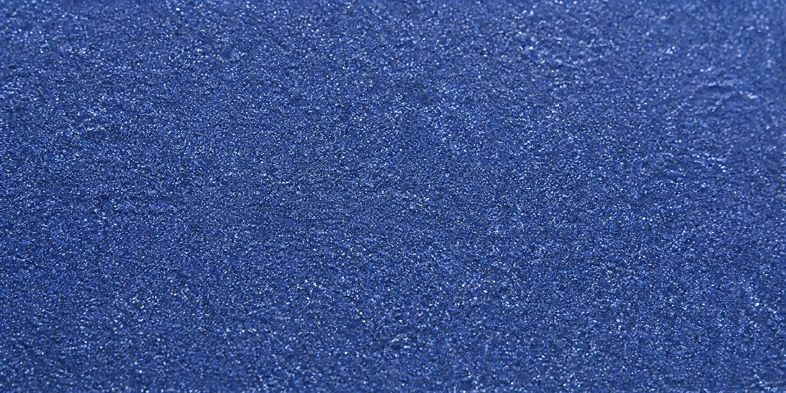 Macro del papel con glitter luna azul, con las partículas separadas brillando sobre la hoja