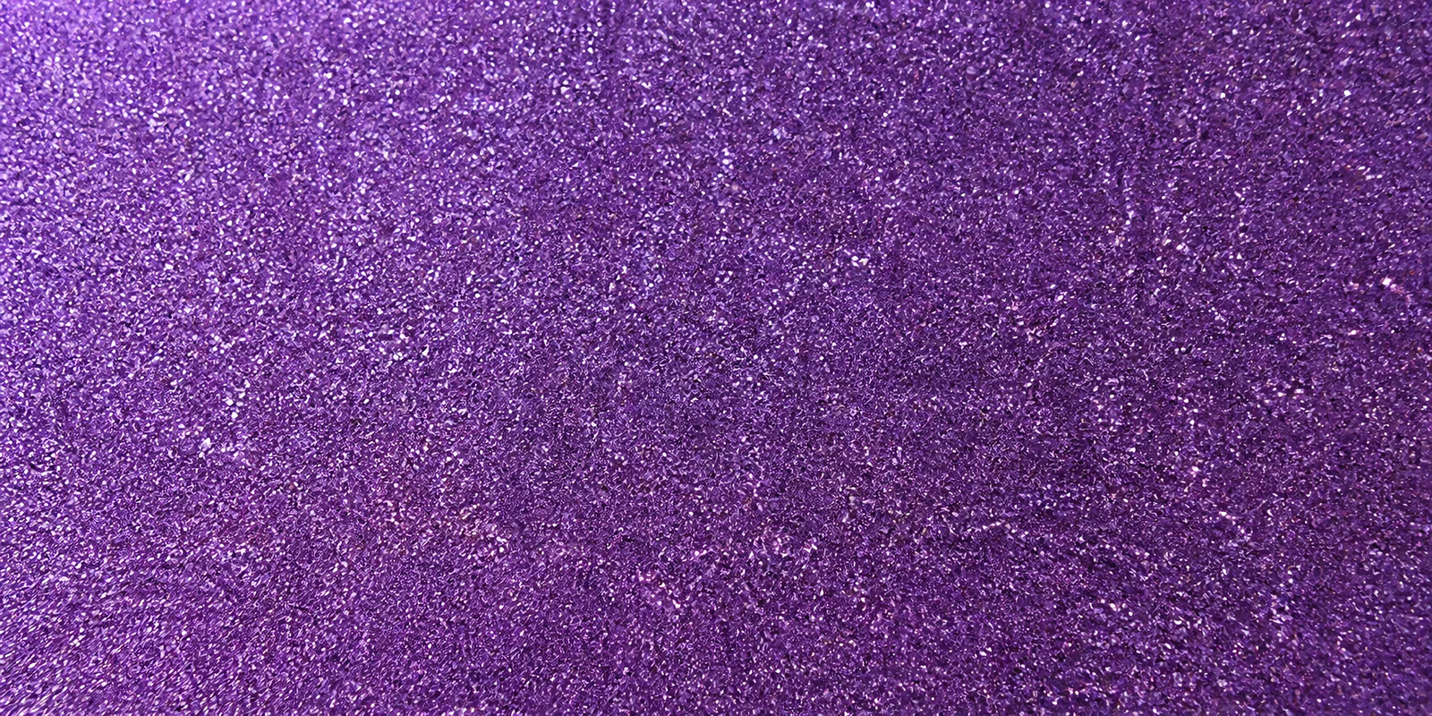 Macro del papel con glitter morado mistico, con las partículas separadas brillando sobre la hoja
