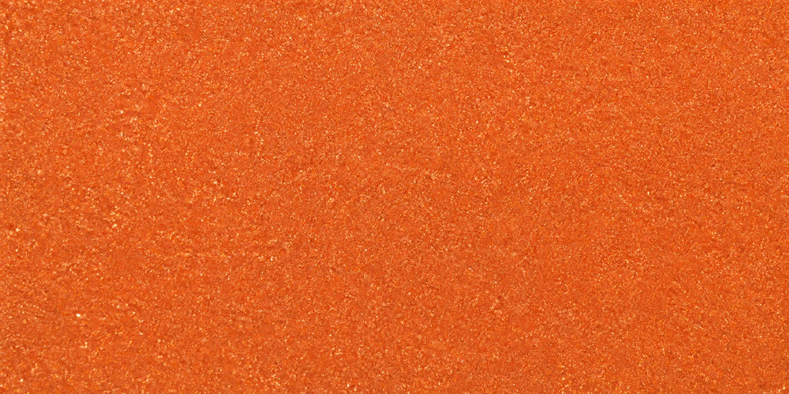 Macro del papel con glitter naranja linterna de fuego, con las partículas separadas brillando sobre la hoja
