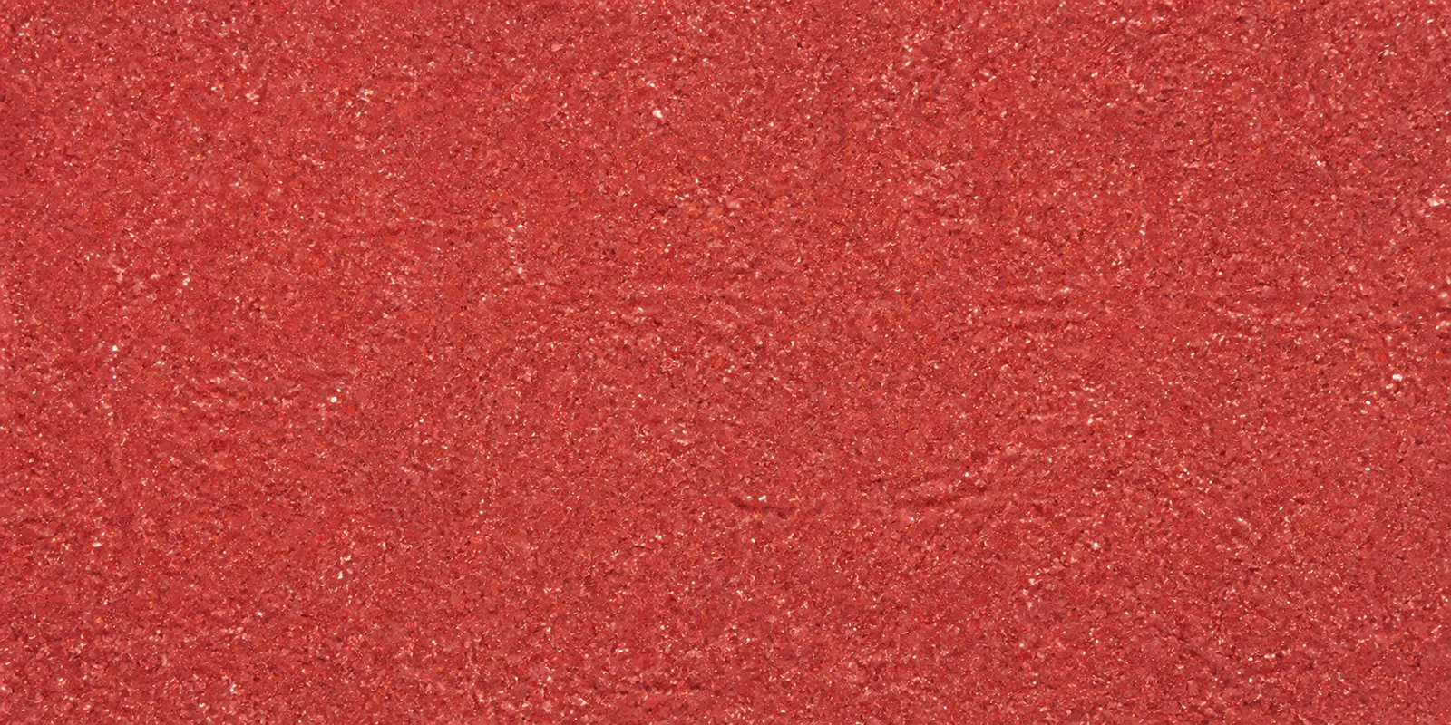 Macro del papel con glitter rojo fenix, con las partículas separadas brillando sobre la hoja