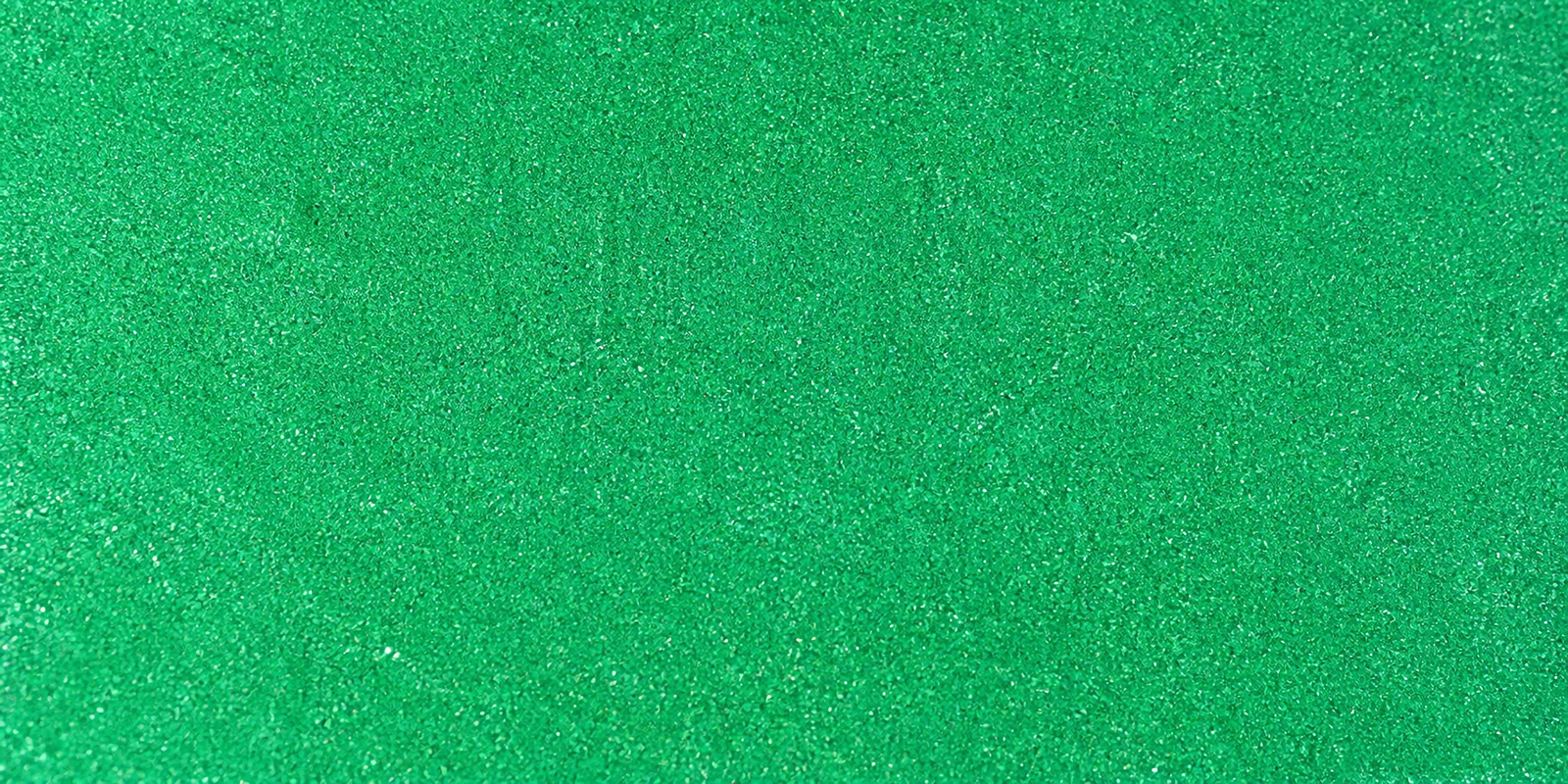 Macro del papel con glitter verde alga del mar, con las partículas separadas brillando sobre la hoja