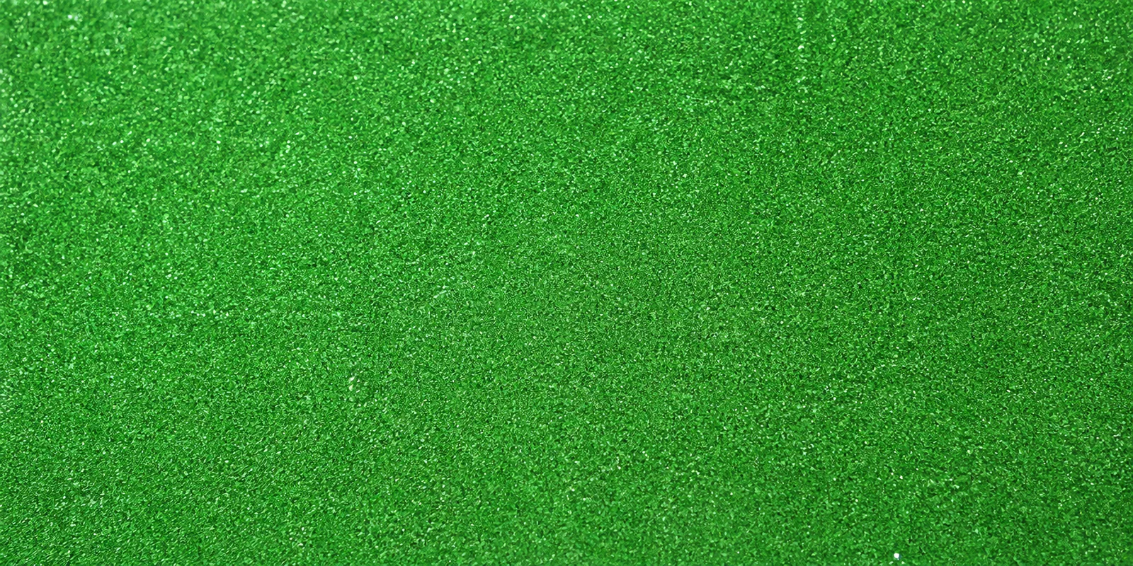 Macro del papel con glitter verde pocion de bruja, con las partículas separadas brillando sobre la hoja