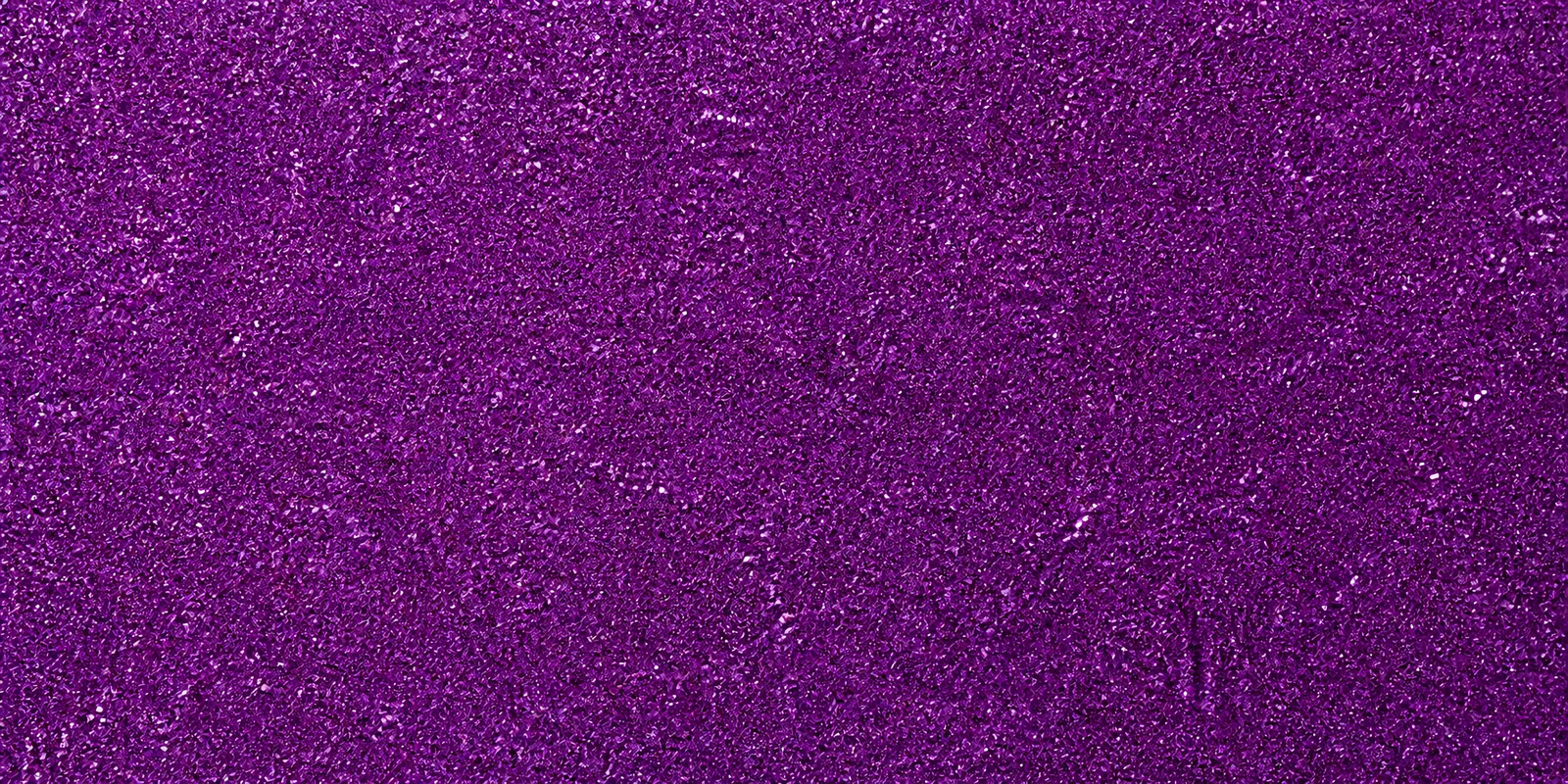 Macro del papel con glitter violeta grial, con las partículas separadas brillando sobre la hoja