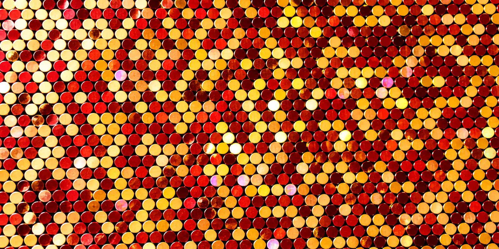 Detalle del papel Glamurina en el tono dorado y rojo selena, con las escamas de glitter a la vista
