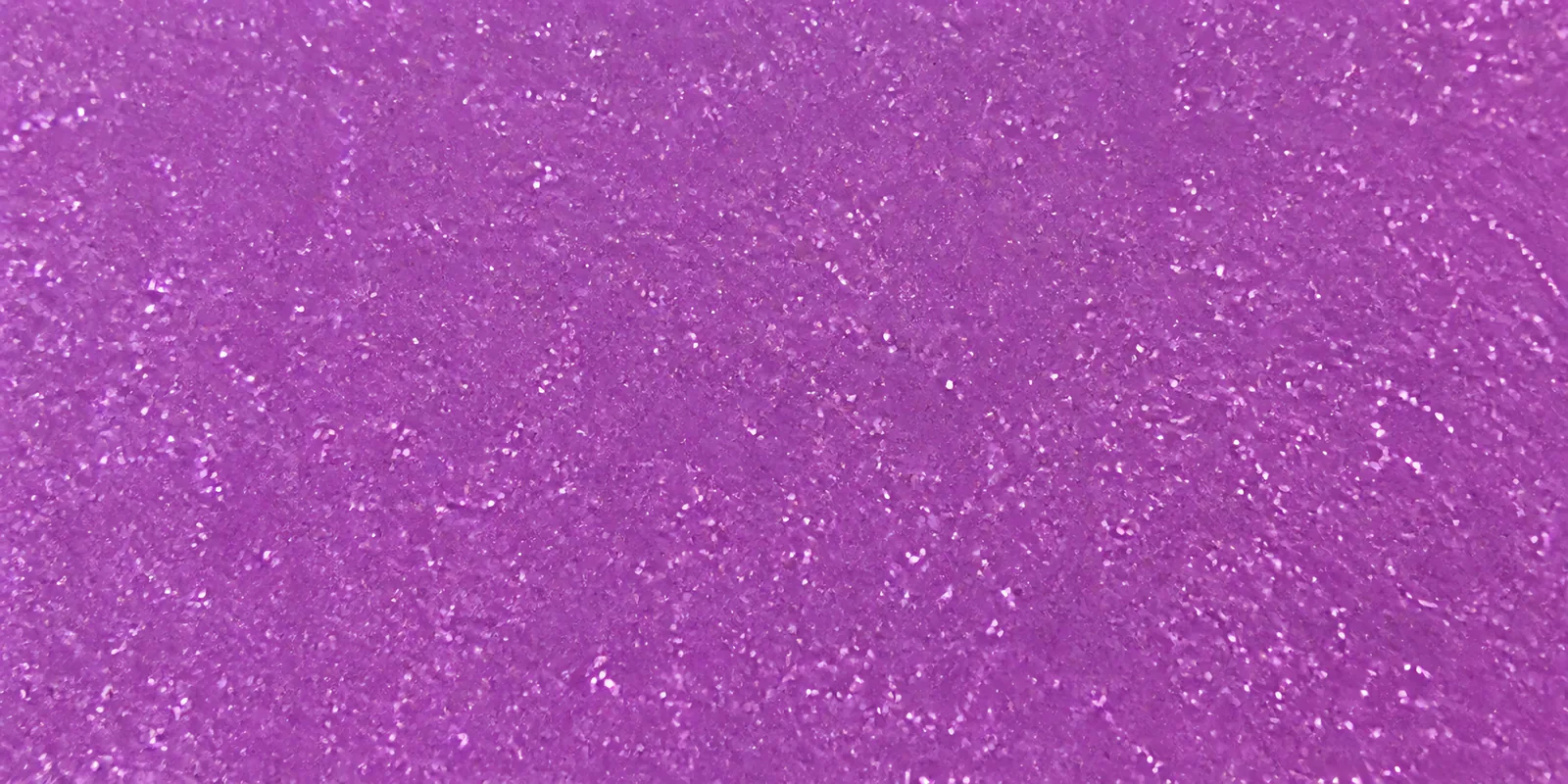 Macro de una hoja violeta de Gliterina, con el glitter bajo el film plástico