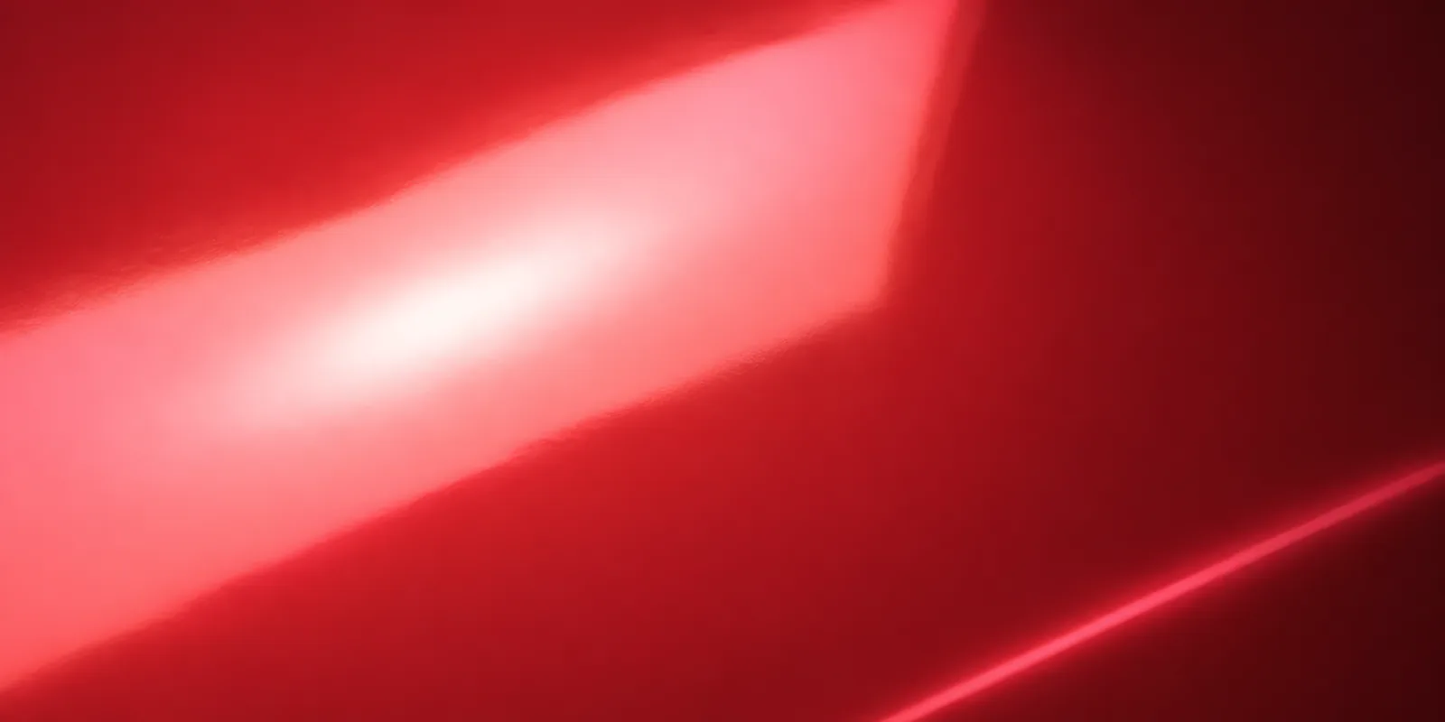 Superficie del papel metalizado Metalina, con el reflejo corriendo sobre la hoja, en el acabado rojo navidad