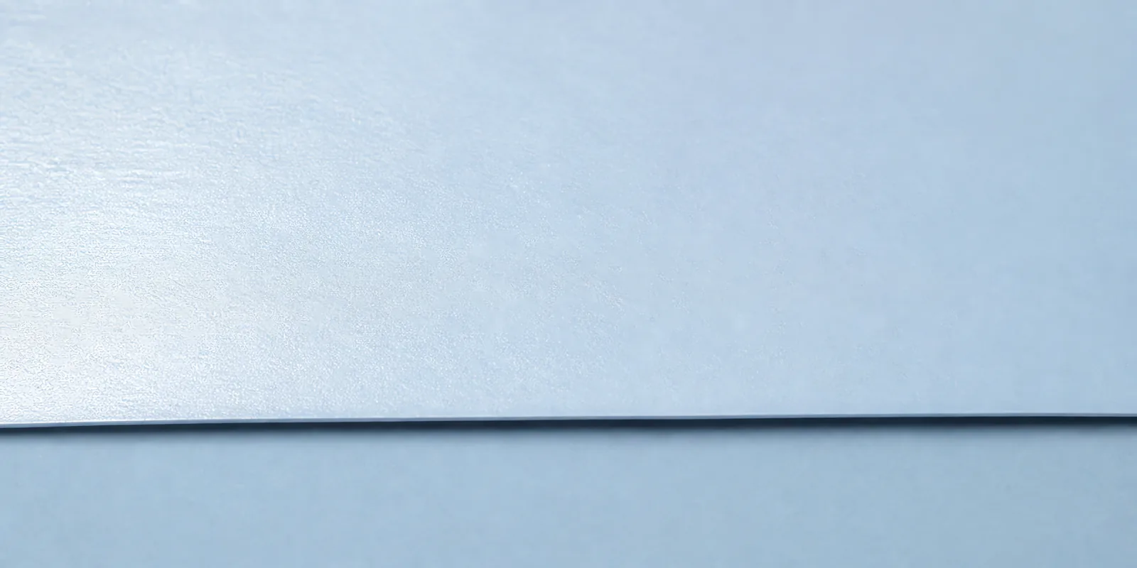 Detalle del papel perlado gris, con el satinado corriendo sobre la hoja
