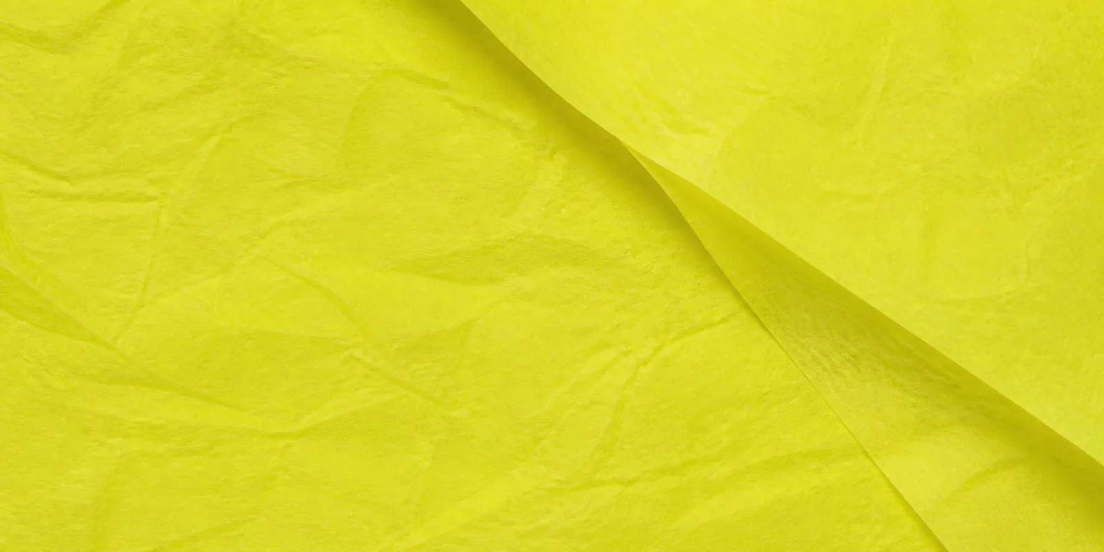 Textura del papel seda amarillo fluor, con sus arrugas finas y sus pliegues
