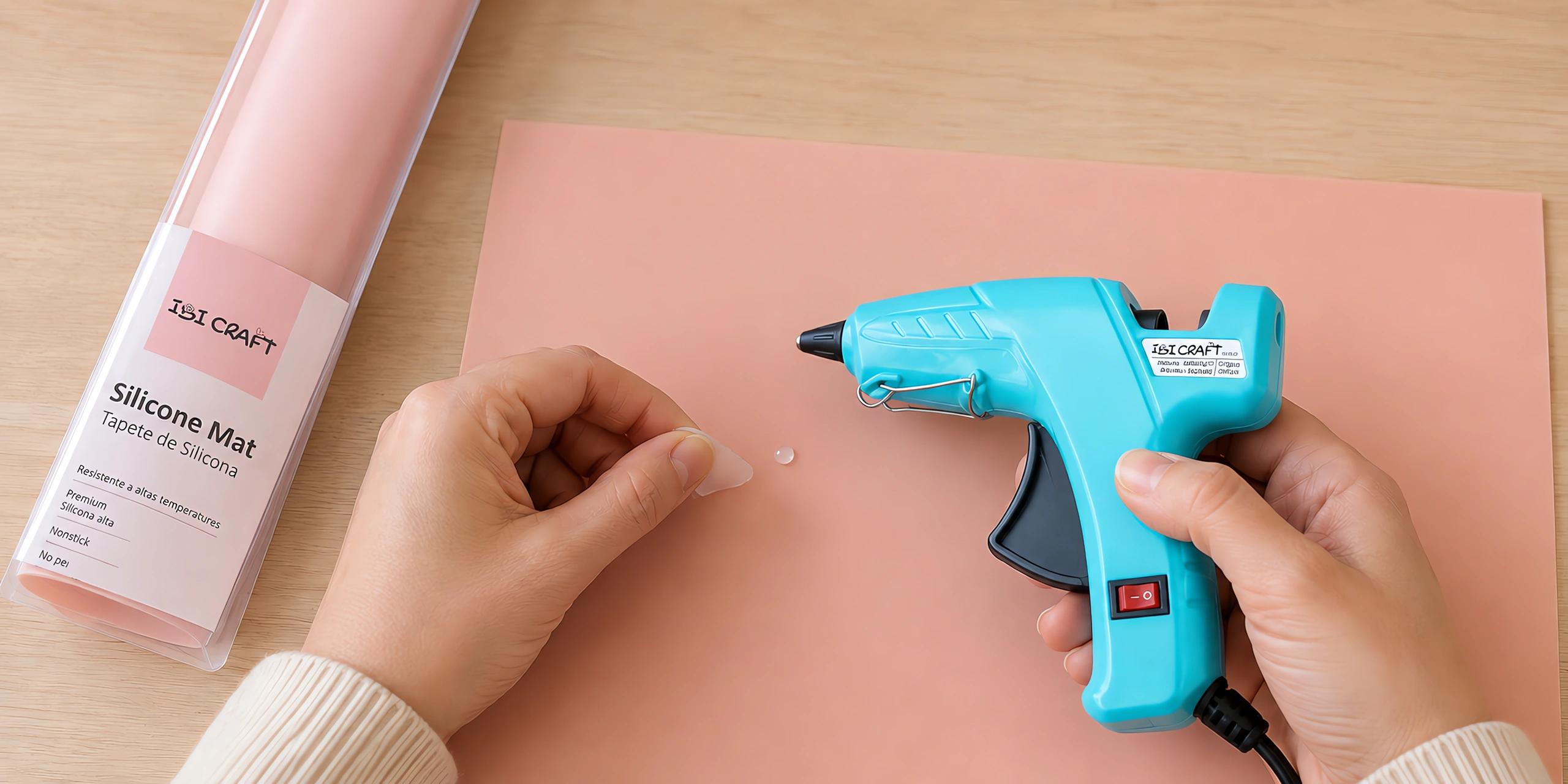 Manos apoyando la pistola encoladora sobre la base de silicona