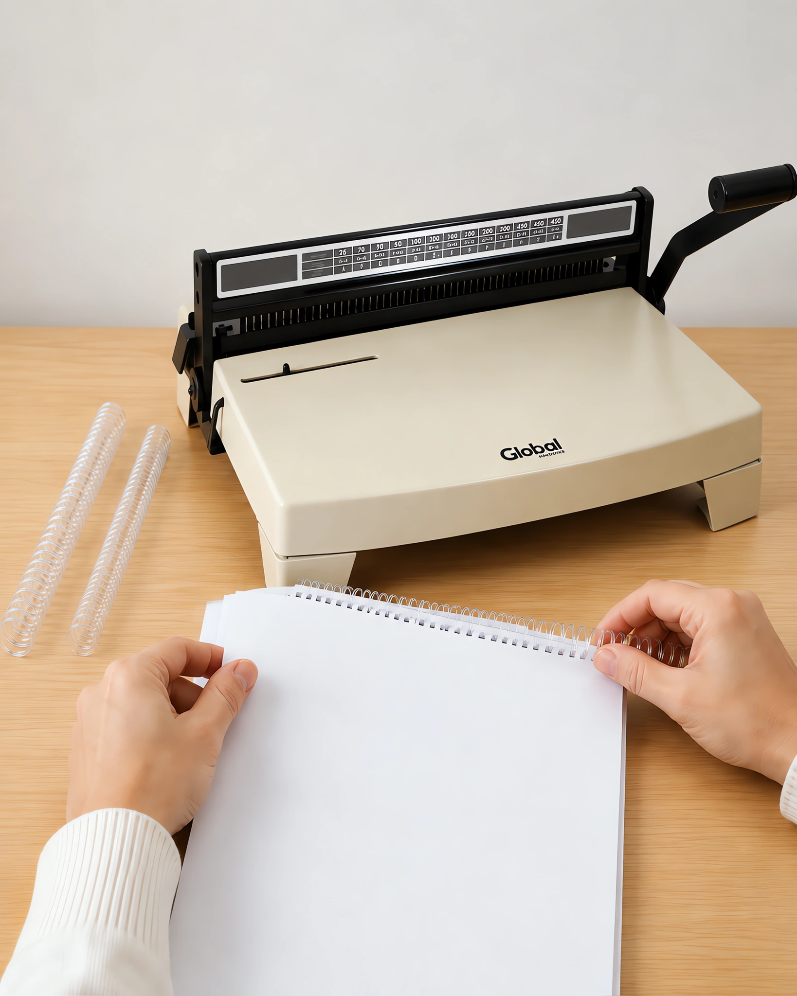 Manos enroscando el espiral plástico en un cuaderno perforado