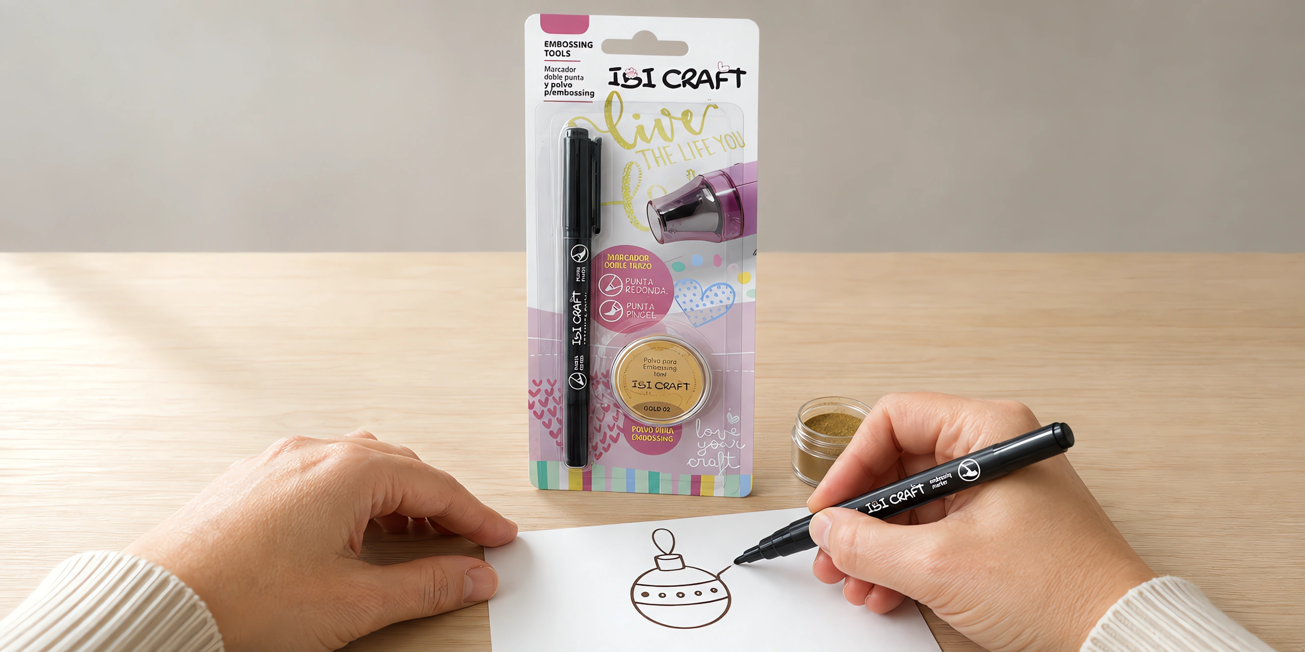 Manos dibujando con el marcador de embossing, con el blíster del set al lado