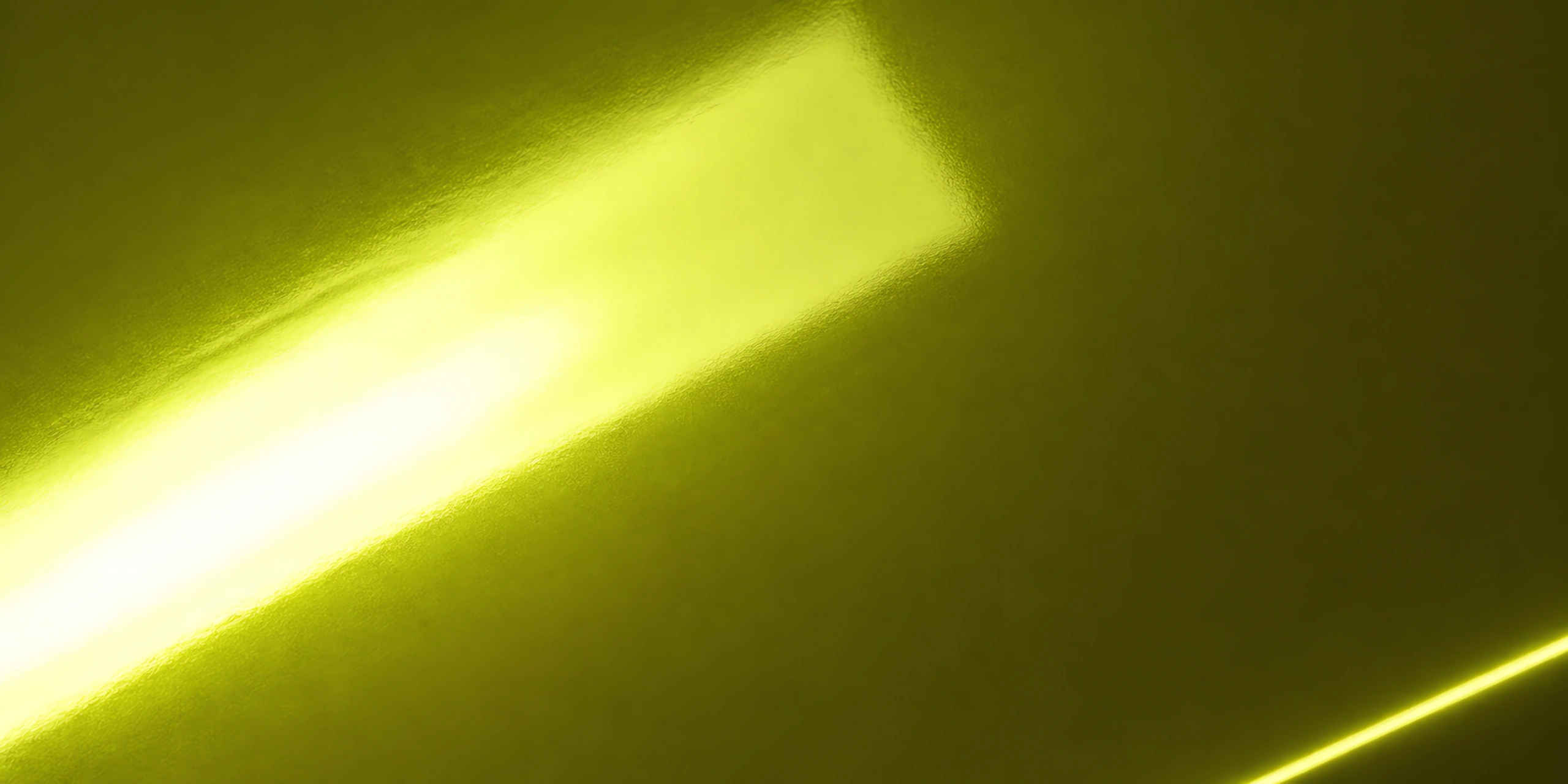 Superficie del papel metalizado Metalina, con el reflejo corriendo sobre la hoja, en el acabado verde ocre