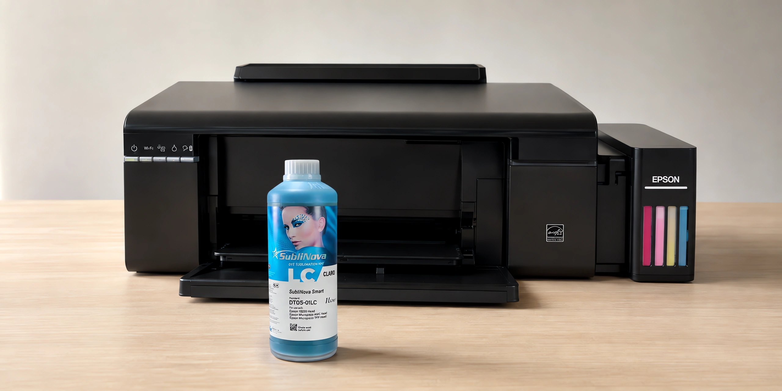 Tinta para sublimar Inktec, Epson serie L en su envase cyan claro, sobre la mesa de trabajo, con la impresora que la usa detrás